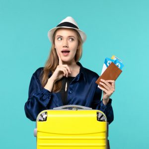 front-view-young-woman-holding-tickets-preparing-trip-light-blue-background-journey-voyage-plane-sea-vacation-travel (1)
